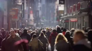 Personas caminan por una calle urbana desenfocada, en una nota sobre vínculos bajo presión, desigualdad emocional y cómo el tiempo, los recursos y la etapa de vida afectan las relaciones personales.