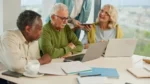 Personas mayores conversan y usan una computadora junto a una persona más joven, en una nota sobre edadismo, cuidado, inclusión intergeneracional y discriminación por edad en Argentina.
