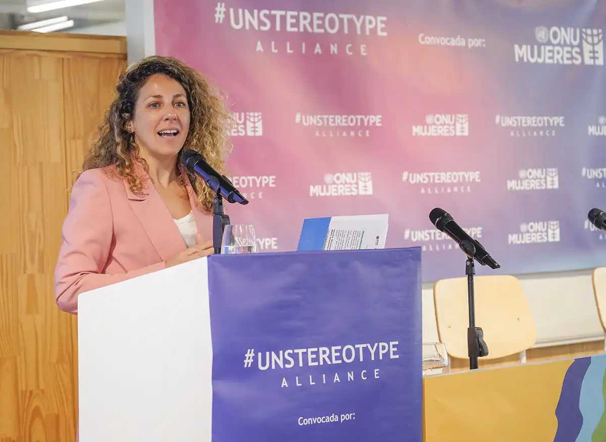 Mariana Massaccesi, especialista de ONU Mujeres Argentina, interviene frente a un micrófono durante el Unstereotype Alliance Summit LATAM, con el fondo institucional de la Alianza sin Estereotipos.