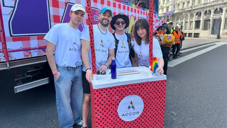 Integrantes de Accor posan en un stand con elementos de los colores del orgullo durante una actividad vinculada a diversidad e inclusión.