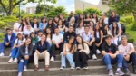 Grupo numeroso de jóvenes y personas adultas posa sobre unas escalinatas al aire libre, rodeado de árboles y vegetación, en una fotografía compartida para la entrevista sobre la Corporación Buen Vivir Juntos Sumamos.