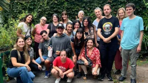 Grupo de jóvenes y personas adultas posa en un jardín rodeado de vegetación, en una fotografía compartida sobre las actividades de Casa Inclusión de Vicente López.