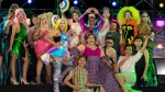 Grupo de artistas drag posa sobre un escenario con vestuarios, maquillajes y caracterizaciones de distintos colores y estilos.