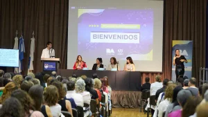 Auditorio con numerosas personas frente a un escenario donde cuatro expositoras participan de un panel y un hombre se encuentra junto a un atril. A la derecha, una intérprete de lengua de señas. En la pantalla central se lee «Bienvenidos» y «10.ª Jornada de Vida Independiente».