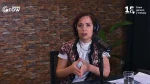 Una mujer con auriculares y chaleco estampado habla ante un micrófono durante una transmisión de los Premios Grow 2026. Detrás se observa una pared revestida en piedra y, en las esquinas superiores, los logotipos de Premios Grow y los 15 años de Grow - Género y trabajo.