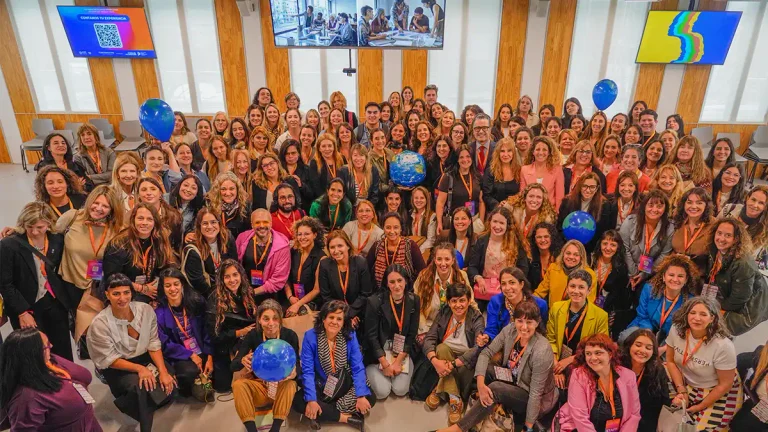 Fotografía grupal de participantes del Unstereotype Alliance Summit LATAM 2026, convocado por ONU Mujeres en la Universidad Torcuato Di Tella. Las personas posan con credenciales naranjas y globos que representan el planeta.